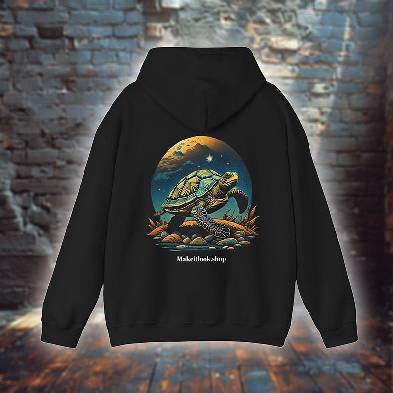 Hoodie „Galactic Wayfarer Tortoise“ mit Motiv: eine Schildkröte vor leuchtendem Mond und Sternenhimmel, Farbe Schwarz