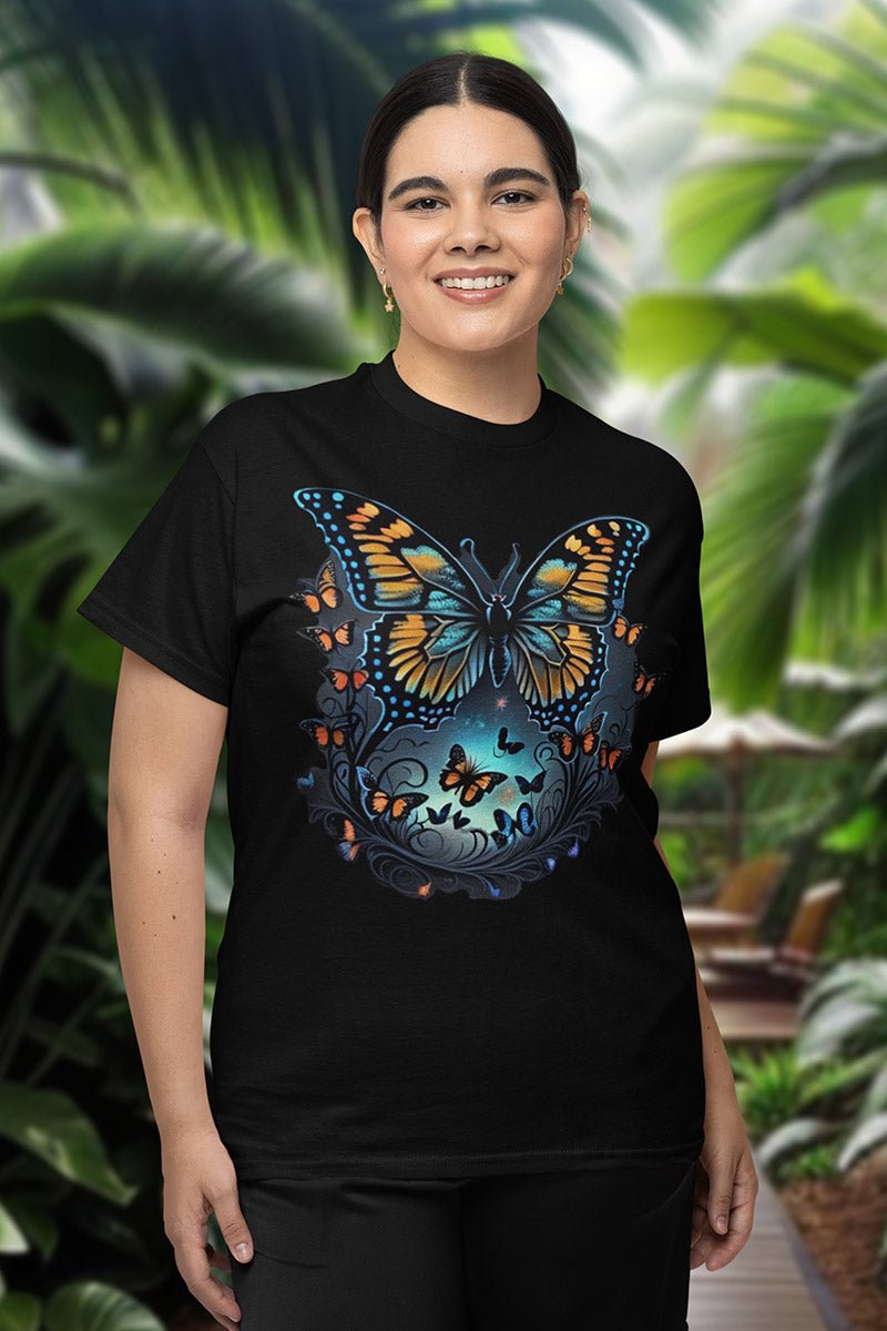Frau lächelt im schwarzen Shirt „Midnight Flutter“, viele kleine Schmetterlinge im türkisen Leuchten